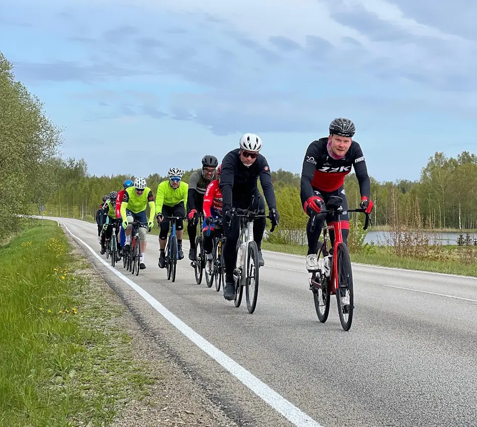 Group of cyclists riding around a bend on a scenic road