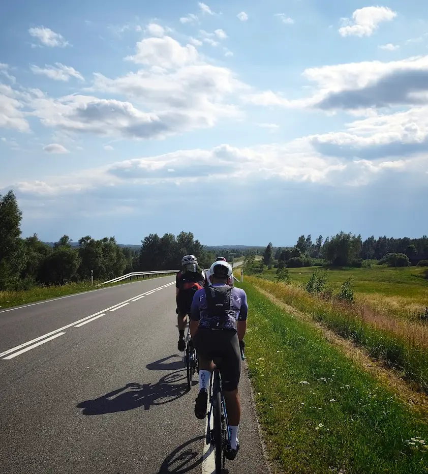 Two cyclists riding a trail under open skies